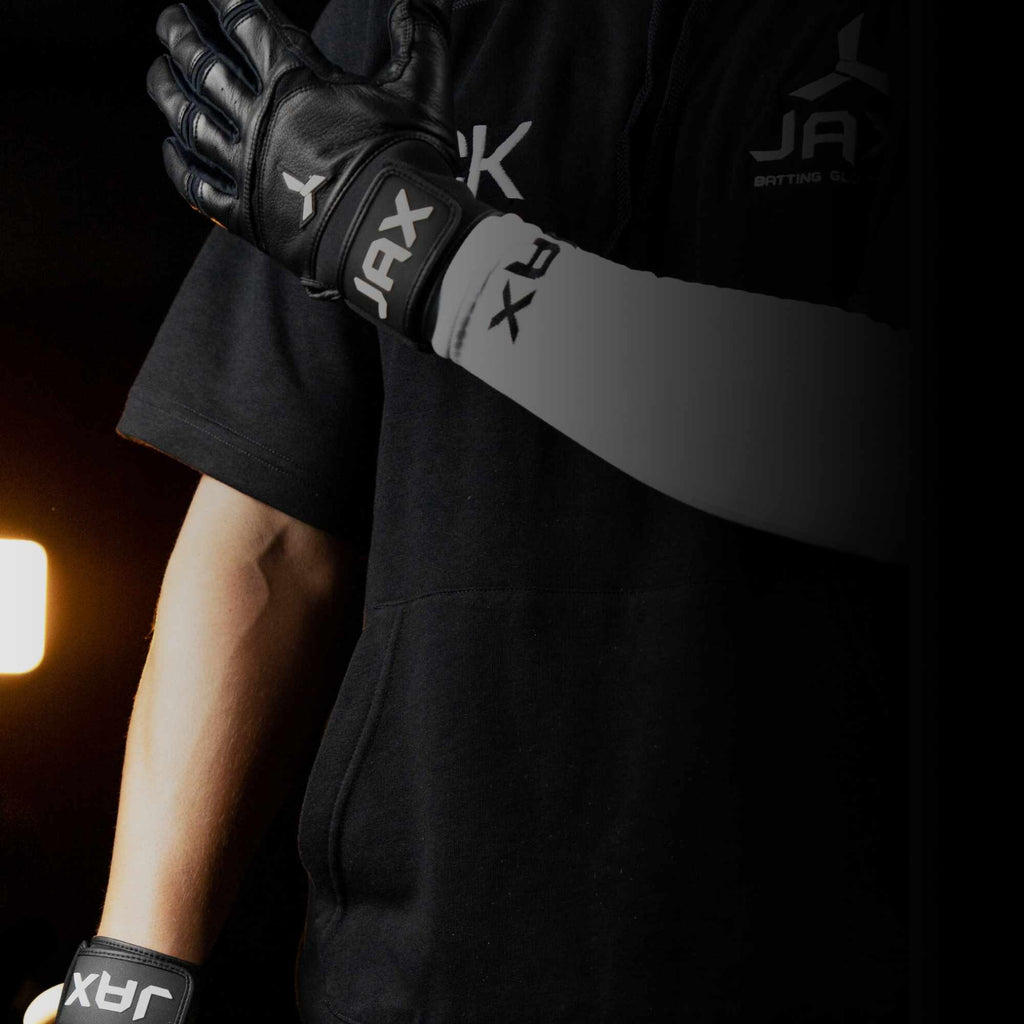 Baseball player with Black Jax Model One Batting Gloves on holding a baseball bat.